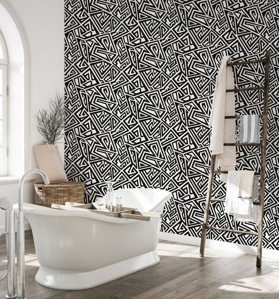 Bathroom interior featuring monochrome wallpaper behind a white freestanding tub.
