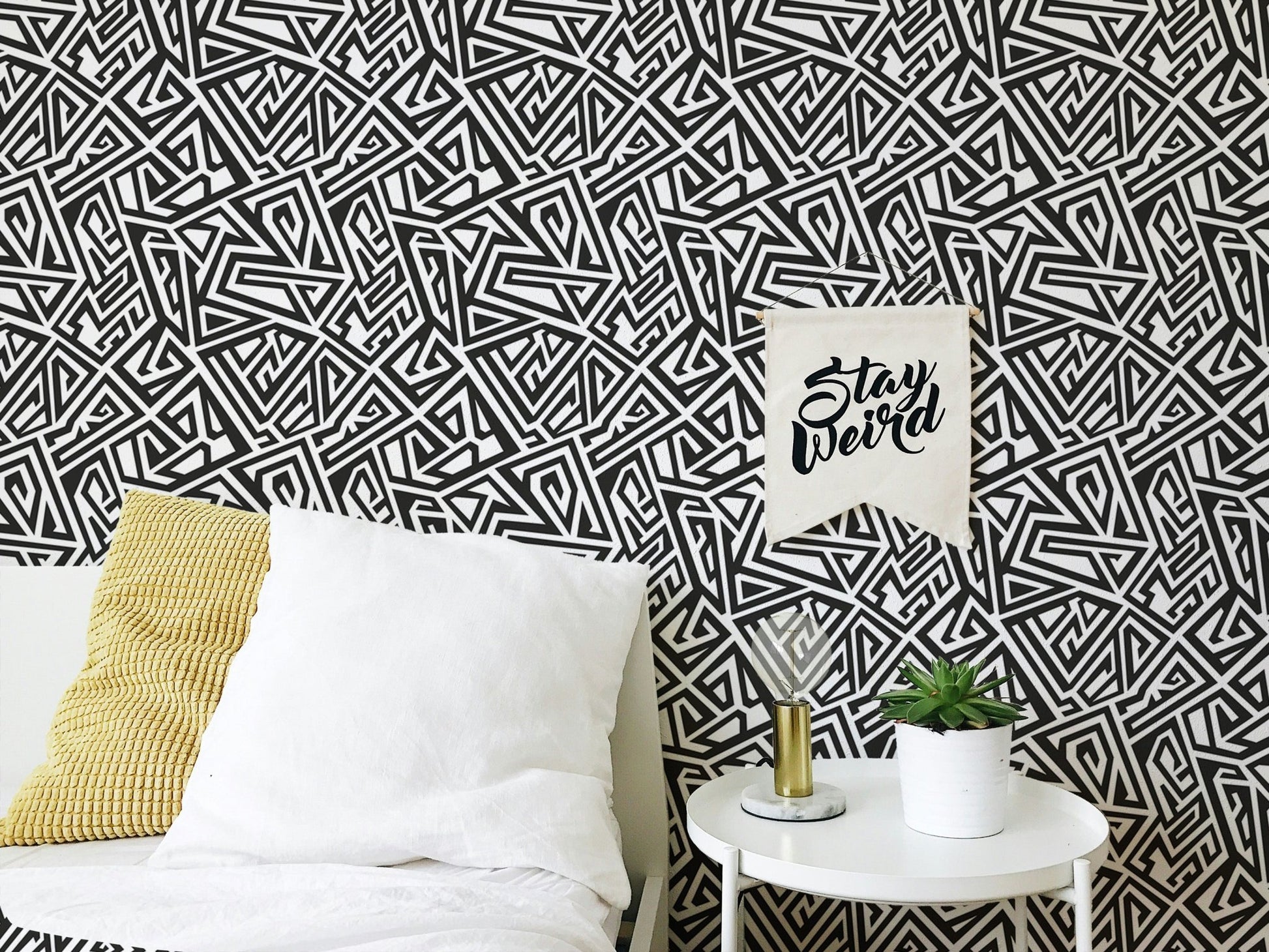 Modern bedroom with black and white ancient geometric wallpaper and white bedding.