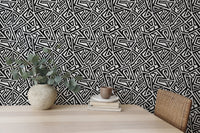 Home desk set against a monochrome geometric wallpaper backdrop.