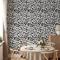 Watercolor geometric wallpaper in a dining space with light wood furniture.