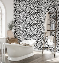 Textured geometric wallpaper in a bathroom with a white freestanding tub.