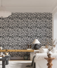 Scattered ink dot wallpaper behind a white sofa and indoor plants.