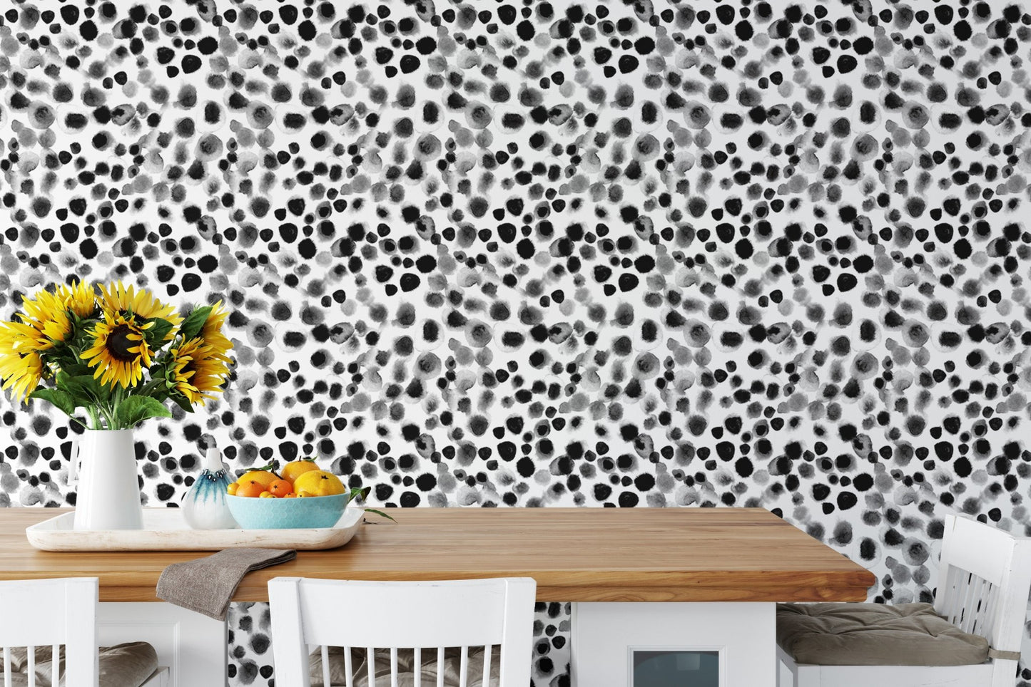 Black ink splatter style wallpaper decorating a bright dining room area.