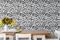 Black ink splatter style wallpaper decorating a bright dining room area.