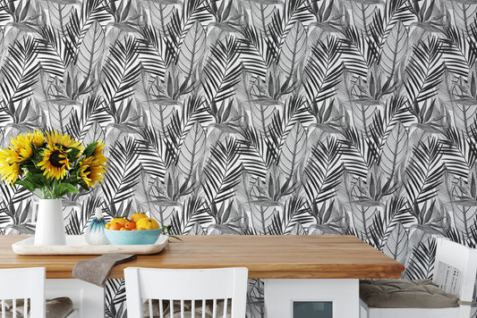 Tropical palm leaves wallpaper behind dining table with sunflowers and fruit.