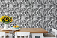 Tropical palm leaves wallpaper behind dining table with sunflowers and fruit.