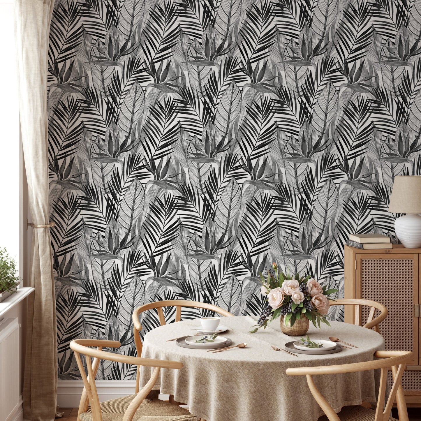 Black and white palm leaves wallpaper in dining room with round table.