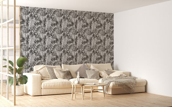 Black and white watercolor wallpaper in living area with beige sofa and plants.