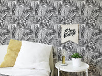 Tropical wallpaper in bedroom with white bedding and yellow cushion.
