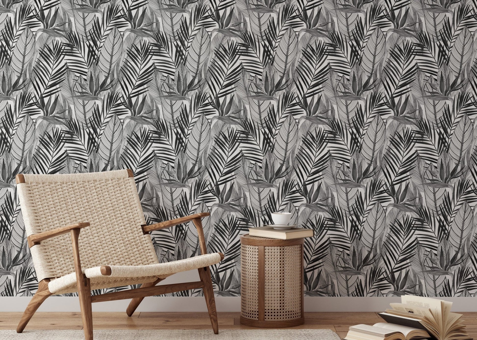 Black and white botanical wallpaper behind light wood chair and side table.