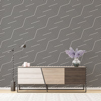 Minimalist stripe wallpaper behind a wooden sideboard and purple vase.