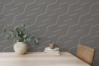 Black and white zigzag geometric stripes wallpaper in a bright workspace.