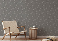 Grey zigzag stripes wallpaper in a living area with a wooden chair and side table.