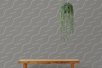 Textured geometric wallpaper behind a wooden bench with hanging plants.