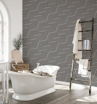 Geometric stripes wallpaper in a bathroom with a white freestanding tub.