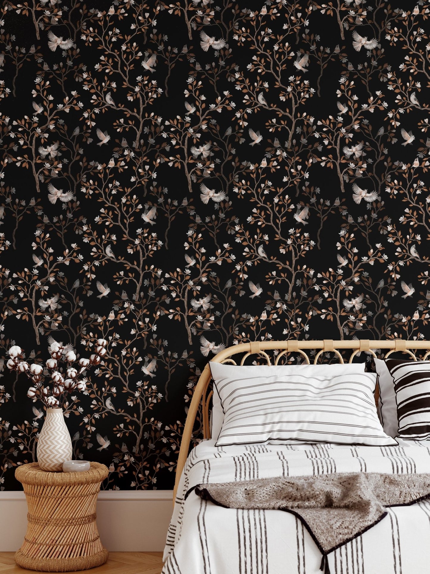 Bedroom wallpaper featuring dark floral patterns behind a white bed and side table.