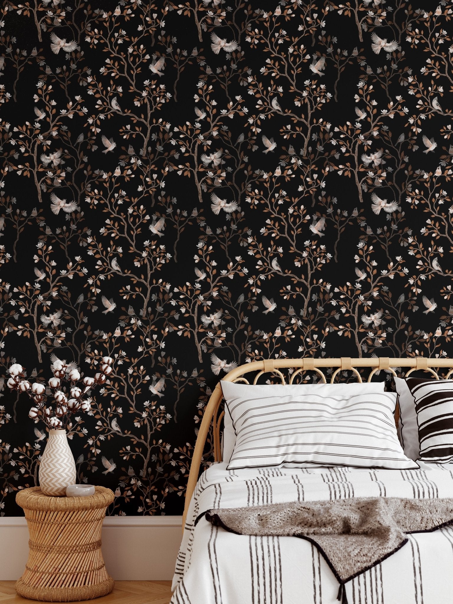 Bedroom wallpaper featuring dark floral patterns behind a white bed and side table.