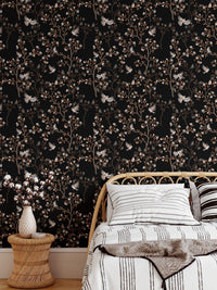 Bedroom wallpaper featuring dark floral patterns behind a white bed and side table.