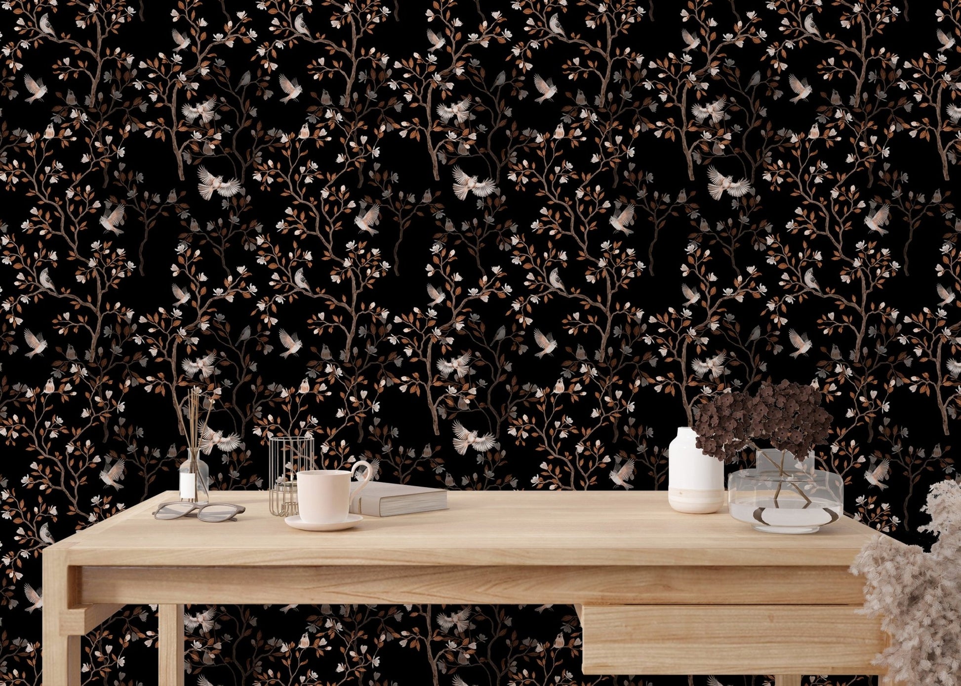 Magnolia tree and birds wallpaper on a study desk wall with office accessories.