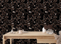 Magnolia tree and birds wallpaper on a study desk wall with office accessories.