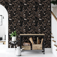 Chinoiserie bird and tree wallpaper in a hallway with a black metal shelf unit.