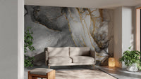 Abstract black gold ink mural with flowing artistic design in living room.
