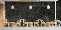 Spacious cafe interior decorated with black stone effect wallpaper mural.