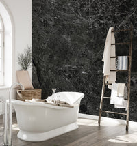 Dark stone wall mural behind a freestanding bathtub in a bright washroom.