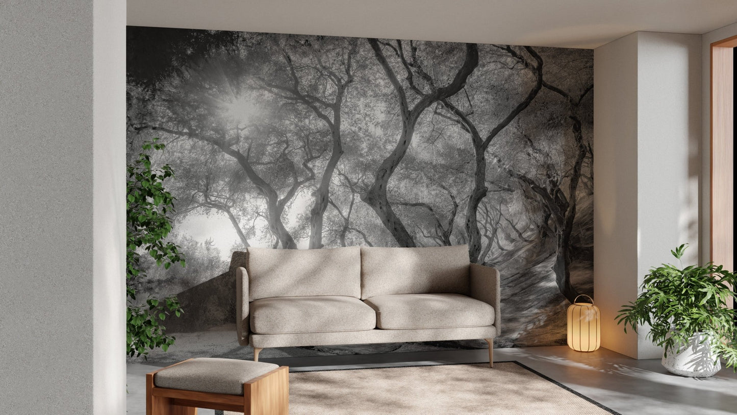 Black and white forest wall mural behind a beige sofa in a living room.