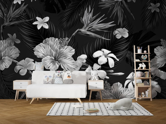 Monochrome tropical flower wall mural in a minimalist nursery with white furniture.