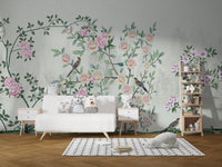 White sofa placed against a light grey floral trail wall mural in kids room.