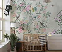 Nursery room with a wooden crib and floral garden design wall mural.