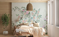 Light wood bed frame and hanging lamp next to a floral trails wall mural.
