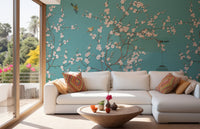 Sunlit living area with pink blossom wall mural and white sectional seating.