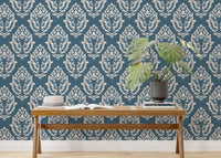 Blue Baroque wallpaper styled with indoor plants and wooden furniture.