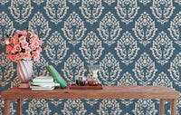 Ornate blue pattern wallpaper behind a rustic wooden bench.