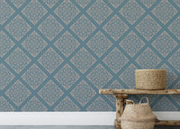 Blue damask wallpaper on living room wall behind wooden bench.