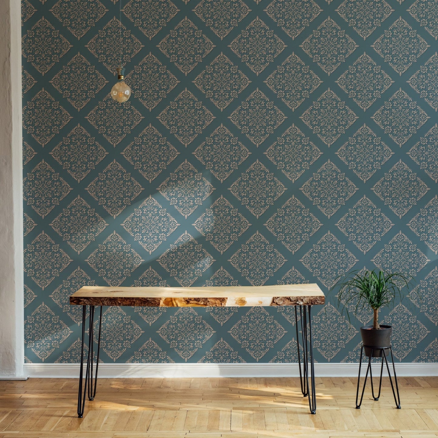 Damask wallpaper in room behind live edge wooden desk.