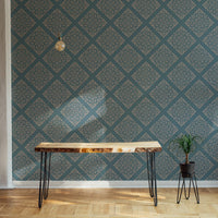 Damask wallpaper in room behind live edge wooden desk.