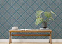 Blue color wallpaper in home office behind minimalist wooden desk.