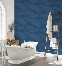 Waterproof blue leaf wallpaper in a bathroom with white freestanding tub.