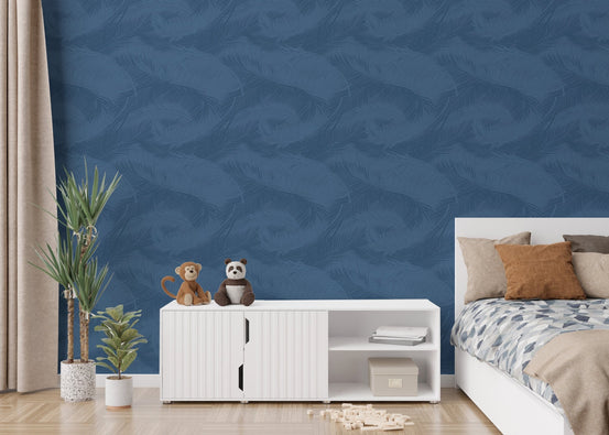 Blue palm leaf silhouette wallpaper behind a bed with neutral bedding.