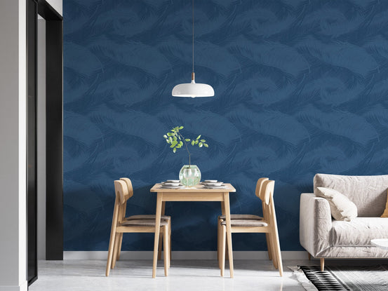 Blue Palm Leaves Silhouette Wallpaper behind wooden dining table and chairs.