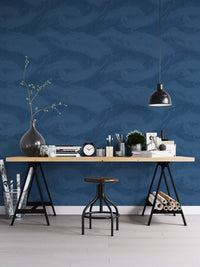 Blue botanical wallpaper in a home office with black trestle desk and stool.