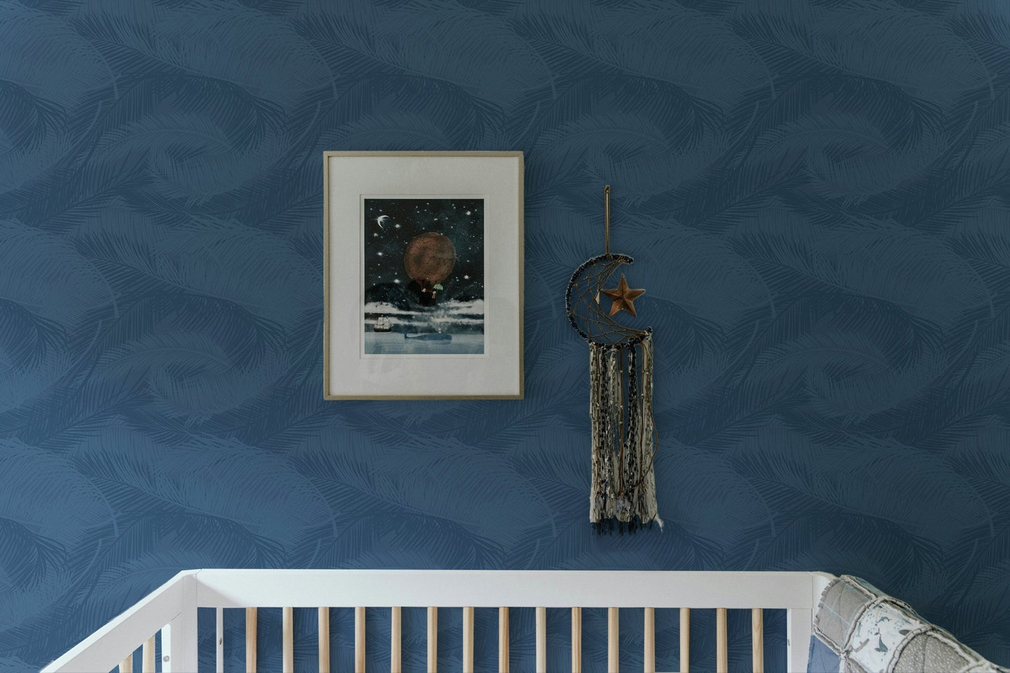 Minimalist blue palm frond wallpaper in a nursery with white crib and frame.