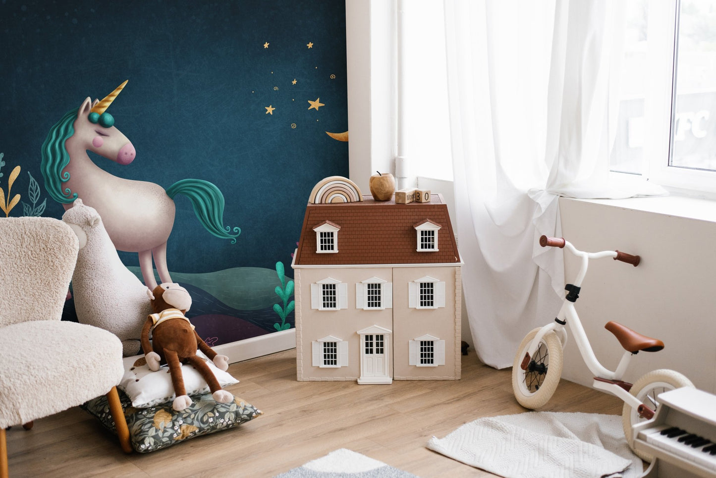 3D unicorn wall mural next to a white dollhouse and toy bike in a play area