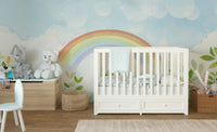 Watercolor rainbow and clouds wall mural in a minimal nursery room.