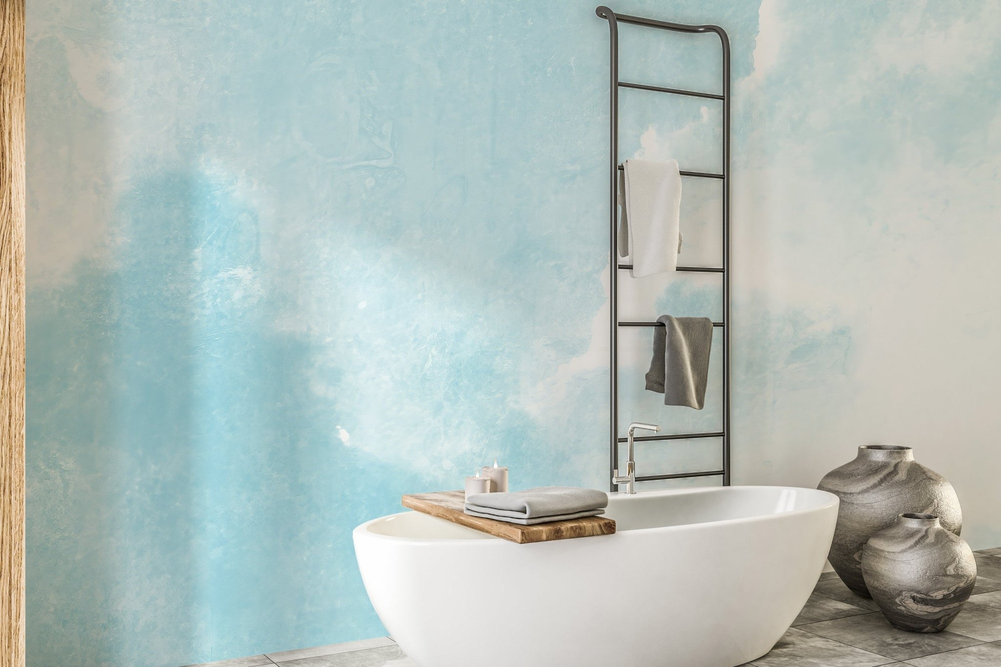 Blue clouds wall mural in a modern bathroom with a white freestanding tub.