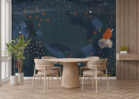 Round wooden dining table set against a blue modern abstract wall mural.