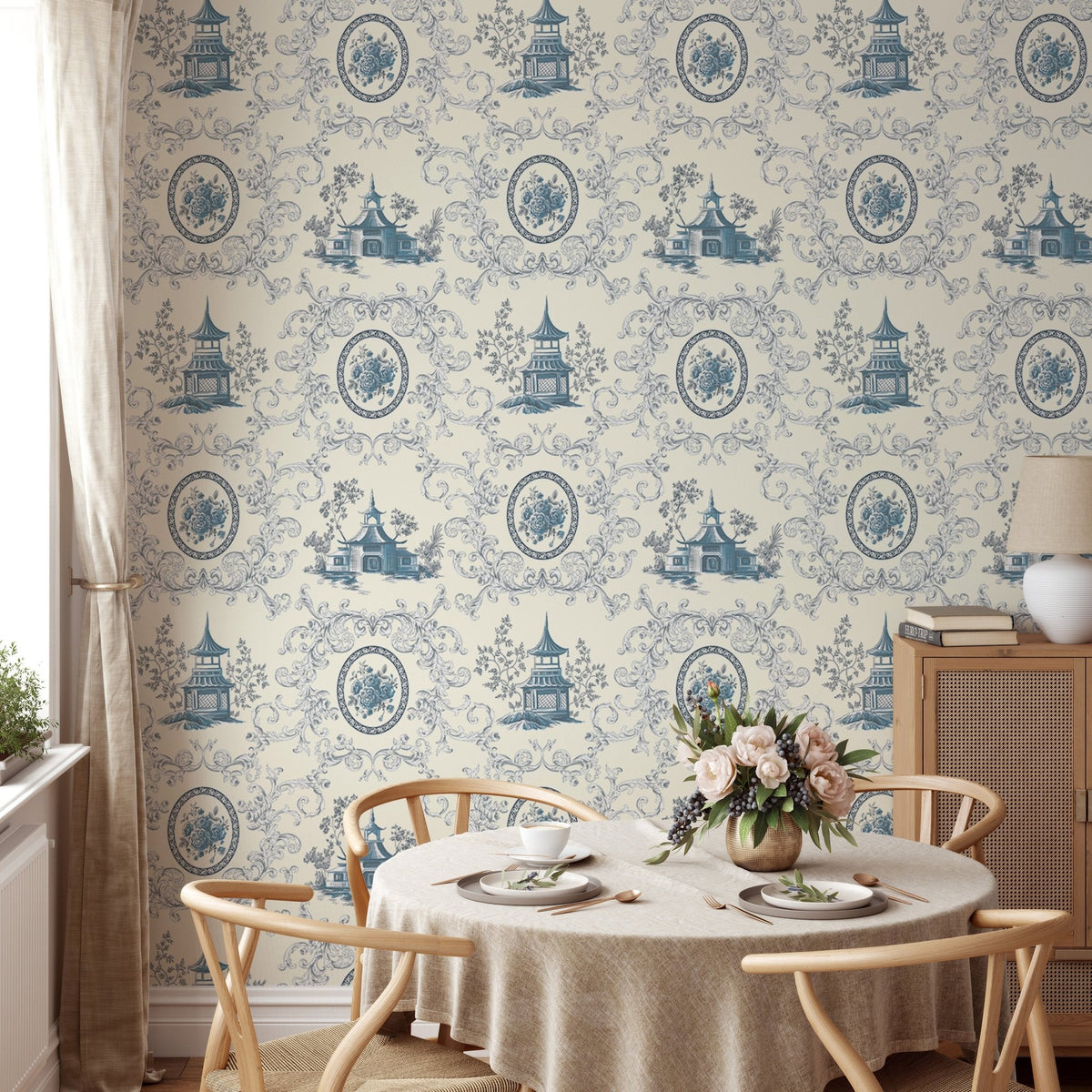 Blue floral wallpaper in a dining room with a round table and wooden chairs.